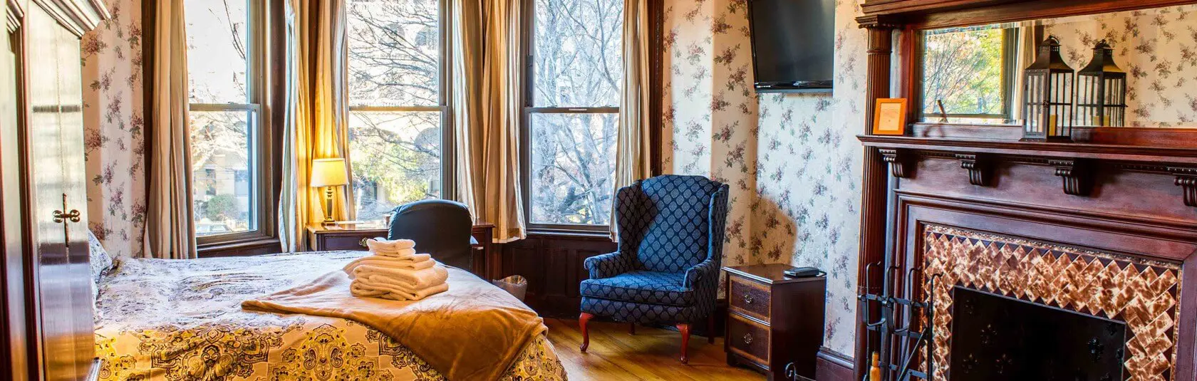 A bedroom with a bed, chair and television.